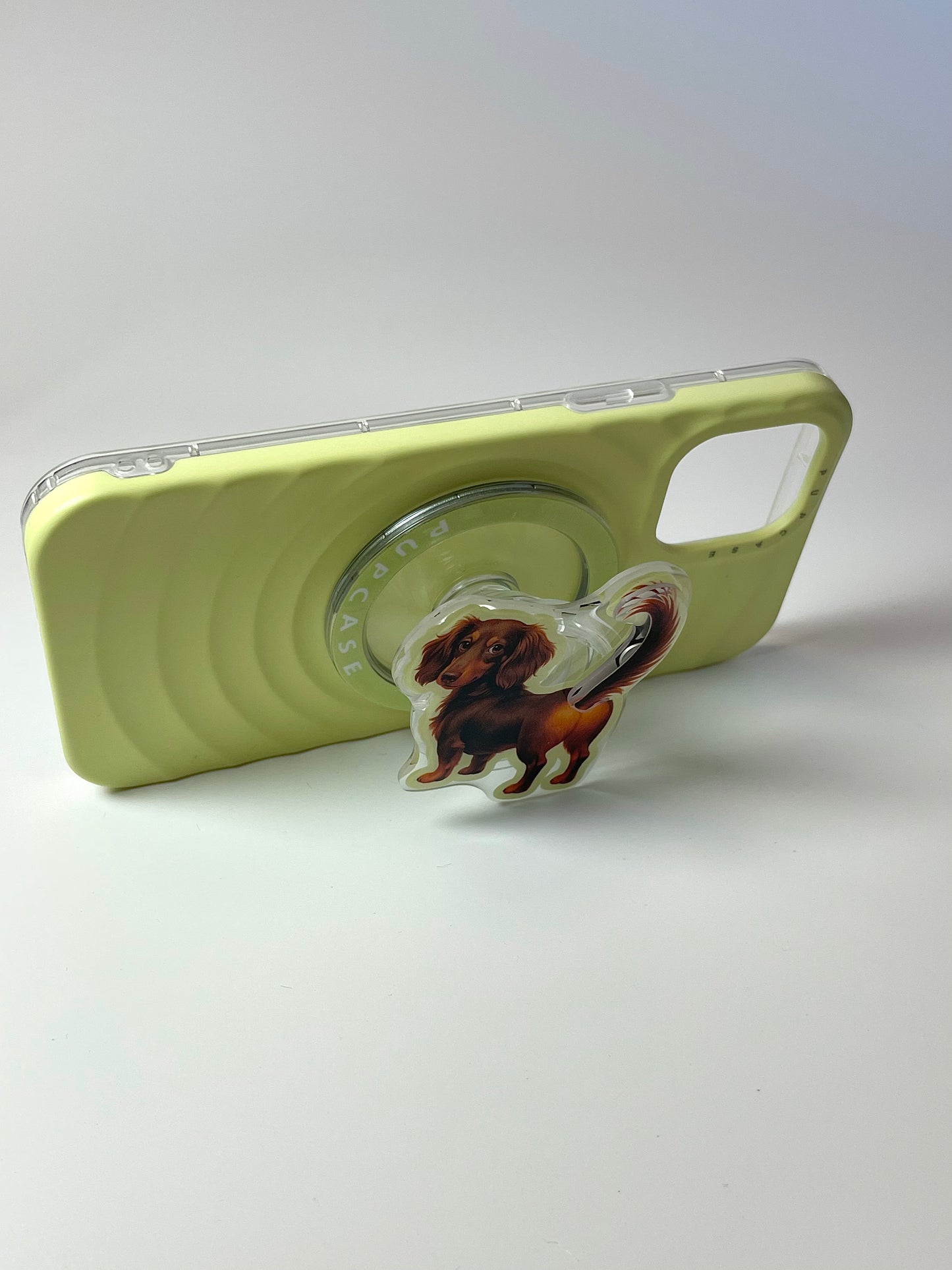 sausage dog phone grip attached to a phone case to make it stand
