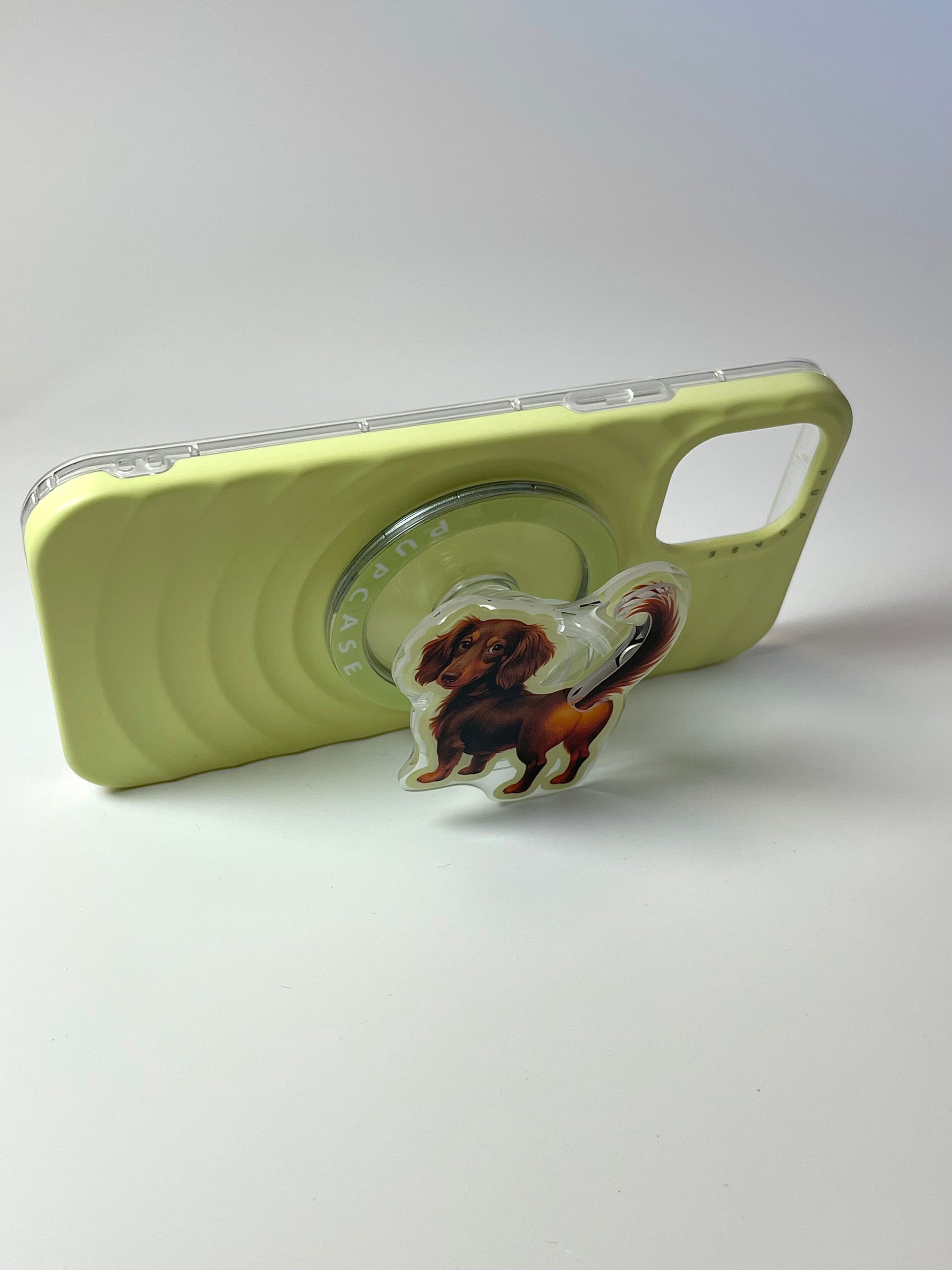 sausage dog phone grip attached to a phone case to make it stand